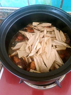 切好的腐竹放入砂锅中。