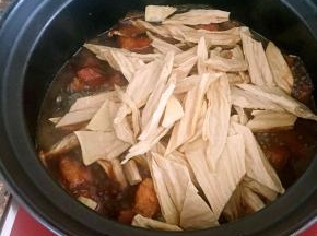 切好的腐竹放入砂锅中。