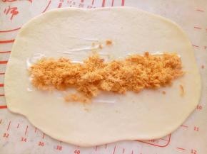 面团依次用擀面杖擀开放上沙拉酱和肉松卷起来。