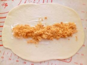 面团依次用擀面杖擀开放上沙拉酱和肉松卷起来。