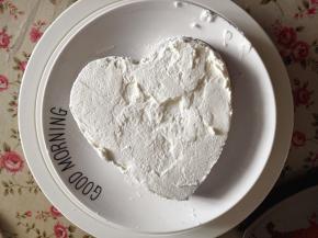 16.   取一片蛋糕片放在盘子里，抹上适量的淡奶油，