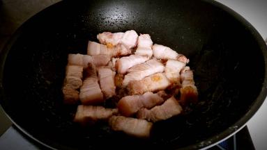 放入五花肉块煸炒出油。