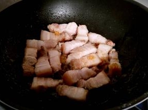 放入五花肉块煸炒出油。