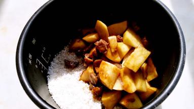 炒好的蔬菜一起倒入电饭煲中。