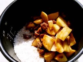 炒好的蔬菜一起倒入电饭煲中。