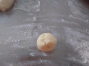 取一个油皮面团压扁，包进一个油酥面团。