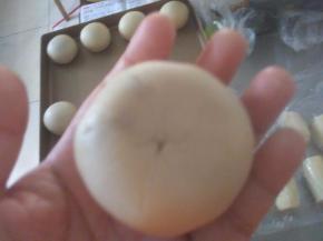 取一个醒发好的卷卷，两头中间捏，擀成中间厚两边薄的圆形，包入油渣馅。