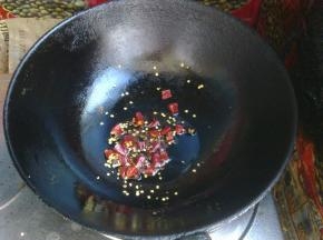 第二天，锅里倒入油，放入大量的花椒和剪碎的干辣椒。