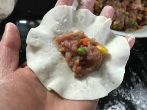 取一面片，放入适量肉馅。