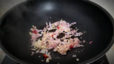 另外起火烧热炒锅，放一点油加热，放入洋葱，辣椒，姜，蒜炝锅出味。