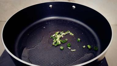 锅中放油，放入一半的葱花炝锅。