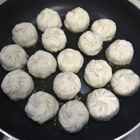 平底锅热油，放入包子中火煎2分钟至底部焦黄