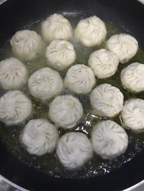 锅中倒入清水，至包子1/2处即可，然后盖上盖子中火煎至无清水，底部焦黄即可，喜欢的出锅时候可以撒一些黑芝麻和小香葱，此次是槐花馅的，怕掩盖槐花本来的香气所以没放黑芝麻后小葱