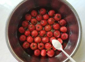 山楂洗两遍后，换干净清水，加1满匙盐在水里，浸泡20分钟。