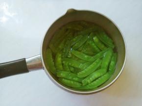 荷兰豆掐去两头，有筋的撕去筋儿，洗净。
起锅倒水，水开（加半匙盐，滴几滴油再焯烫，会使蔬菜的颜色更加鲜艳）。放入荷兰豆，焯烫十几秒捞出，冲凉水后控干。