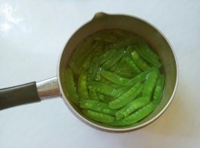 荷兰豆掐去两头，有筋的撕去筋儿，洗净。
起锅倒水，水开（加半匙盐，滴几滴油再焯烫，会使蔬菜的颜色更加鲜艳）。放入荷兰豆，焯烫十几秒捞出，冲凉水后控干。