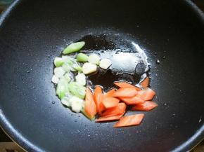 起锅少许油，下葱花蒜片爆香，下胡萝卜片。