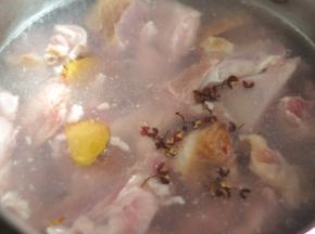 羊肉切成块状，冷水下锅，锅里放入姜片和花椒。水开后捞出。