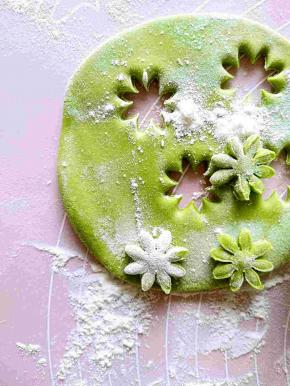 取一小块儿绿色的面团擀开之后用下工具刻几个小花。