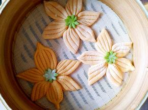 把绿色的小花放在黄色的馒头上。盖好盖子醒发。