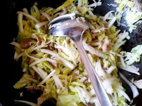 把白菜倒入锅中翻炒至变软。