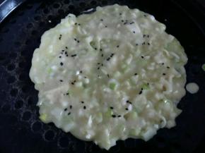 电饼铛刷少许油，盛两勺子面糊倒入电饼铛，快速摊平，上面撒少许黑芝麻。