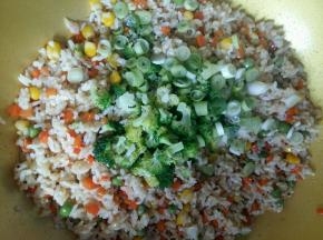 米饭翻炒1分钟，倒入焯好的西兰花，葱花，翻炒1分钟。