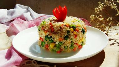 碗上盖一个盘子，压住碗然后倒扣。切一个小番茄装饰。