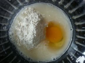 在小米浆中加入少许面粉，一颗鸡蛋。搅拌均匀。面粉也可以最后加，到一定要少量多次加入。