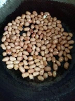 烧水的同时炒花生。热锅凉油倒入花生米，小火不断翻炒。（油只用一点点就行，也可以不放油。）