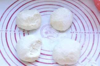 5、然后取出面团揉匀，排出里面的空气。分割成四等份，滚圆。盖保鲜膜静置10分钟。