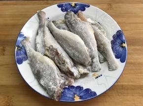 把腌好的小黄鱼用厨房纸吸干水份后拍上一层面粉。