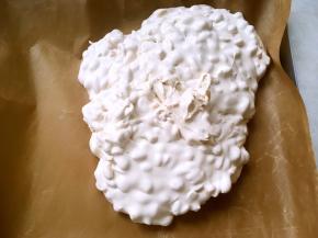 之后将翻拌好的牛轧糖倒在油纸上，利用不粘模具，趁热整理好形状，用擀面杖将表面擀平正，放一旁凉透