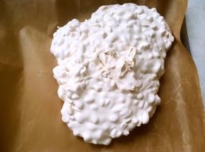 之后将翻拌好的牛轧糖倒在油纸上，利用不粘模具，趁热整理好形状，用擀面杖将表面擀平正，放一旁凉透