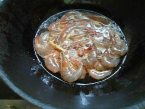 腌好的虾沥干水，起锅热油，放入花椒粒，姜丝爆香。放入大虾，大火炸制一分钟使外壳水分变干。