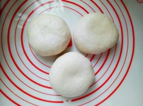 将发酵好的面团取出，分成3等份，揉圆，盖上保鲜膜松弛10分钟。