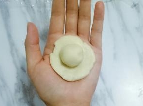 取油皮一份，揉圆，按扁，放上油酥