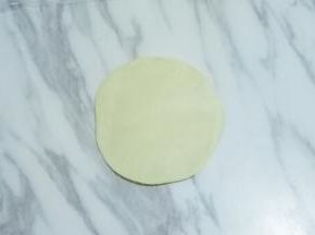 按扁，用擀面杖擀成中间稍厚，四周稍薄的面皮