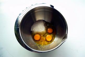 将鸡蛋、细砂糖、清水（用等量的纯牛奶代替更香），柠檬皮屑放入打蛋盆中。