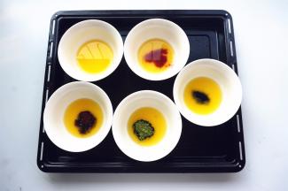 黄油隔水融化后平均分成5份，其中4份分别加入可可粉、竹炭粉、抹茶粉、蔓越莓粉。