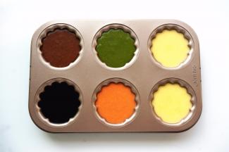 将各色的面糊分别倒入模具中，在桌子上轻敲几下，震荡出大气泡。