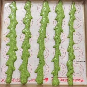 分出三分之一的蛋糕糊加入绿色素，调成深绿色，混合均匀后，装入裱花袋，如图挤出西瓜皮的纹路，放入已预热好的烤箱中层，180度烘焙一分钟