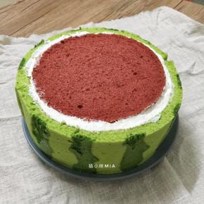 中间的部分完成后，在蛋糕体的外边也抹上一层淡奶油，然后围上绿色的蛋糕片，用丝带围一圈，放入冰箱冷藏固定一下