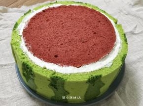 中间的部分完成后，在蛋糕体的外边也抹上一层淡奶油，然后围上绿色的蛋糕片，用丝带围一圈，放入冰箱冷藏固定一下
