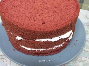 将红曲蛋糕平均分为三片，每片中间抹上淡奶油，如喜欢水果可以放上喜欢的水果，我这里是抹上淡奶油就组装起来了