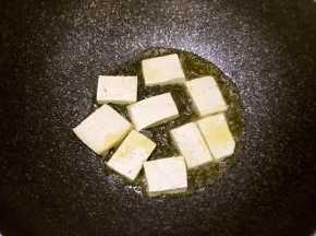 豆腐捞出后用厨房纸吸干水份，锅中热油煎豆腐