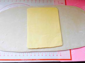 取出冷冻好的面团，擀成长方形，长度可以包裹住黄油片即可，台面要撒手粉