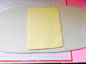 取出冷冻好的面团，擀成长方形，长度可以包裹住黄油片即可，台面要撒手粉