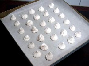 烤盘垫上吸油纸，然后挤出蛋白糖。