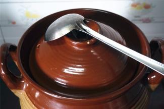 用勺子盖着砂锅盖的排气孔。